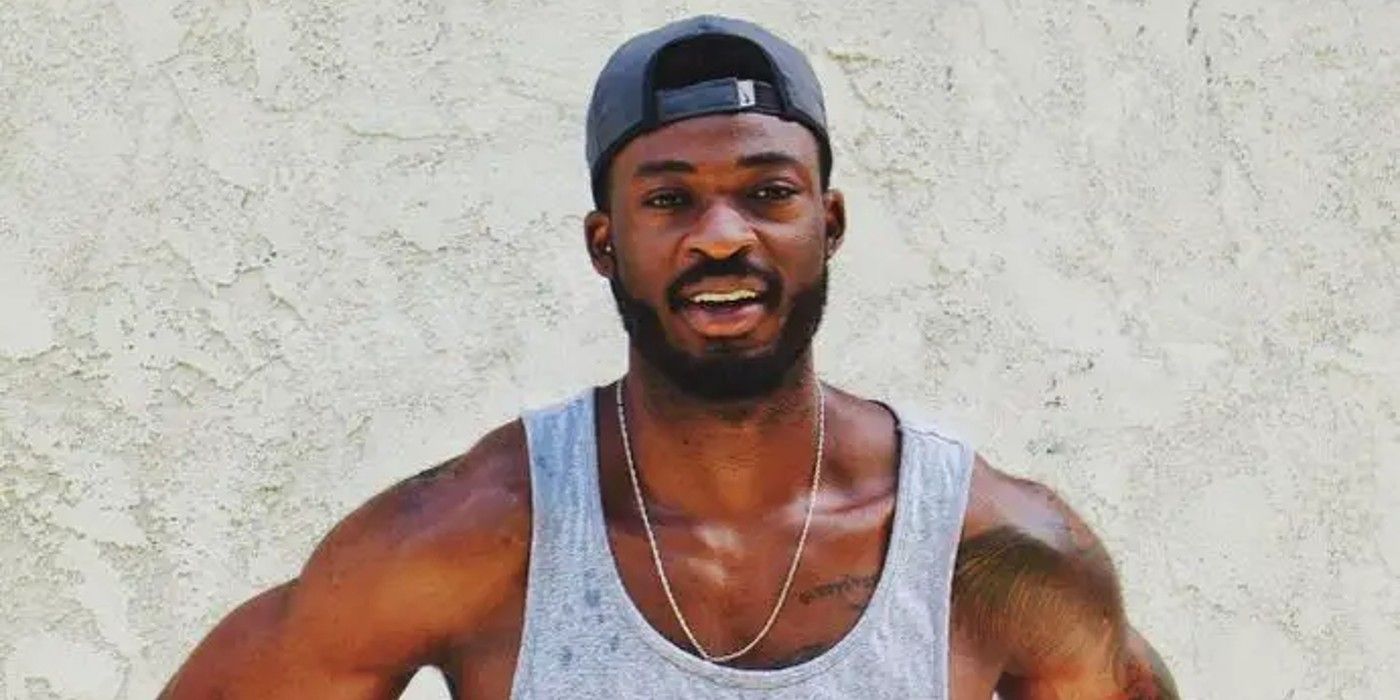 Dotun Olubeko The Bachelorette wearing tank top and baseball cap smiling
