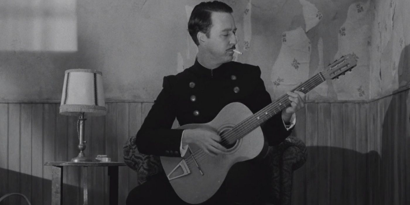 Edward Norton playing a guitar in The French Dispatch