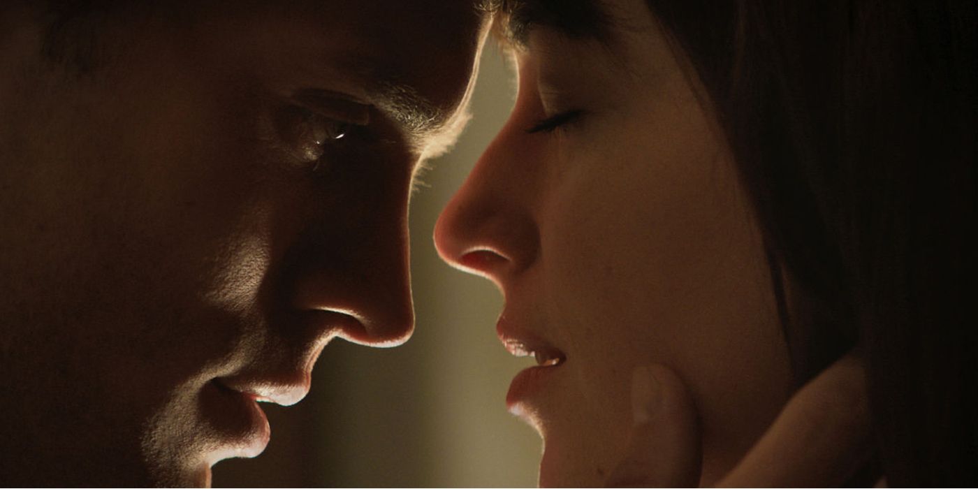 Ana closes her eyes as she and Christian's faces get close before kissing in Fifty Shades of Grey.