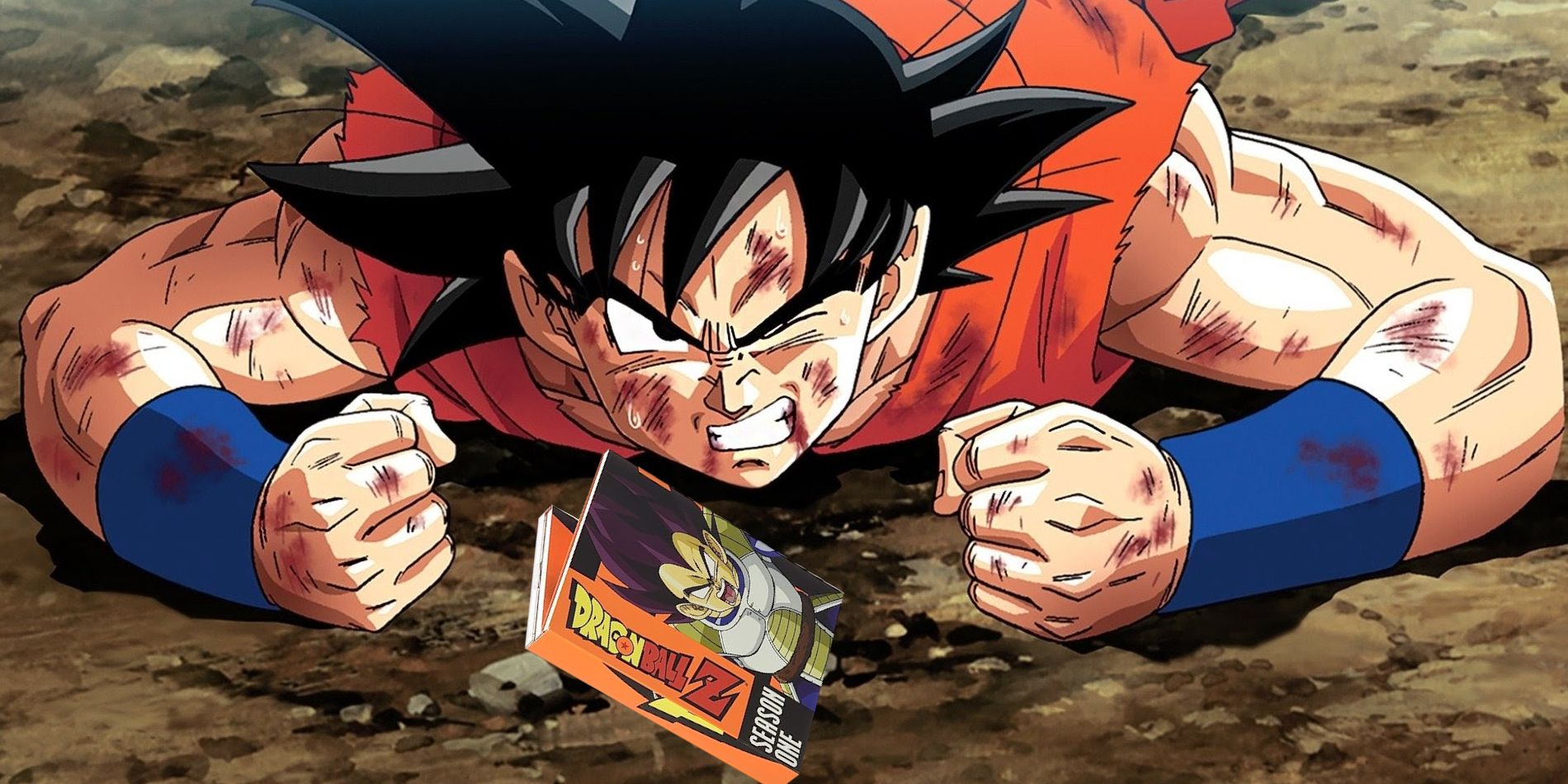 Image shows Goku laying on his stomach after getting hurt. One year is closed and his arms are outstretched with both fists clenched with a Orange DVD of Dragon Ball Z season one in front of him.