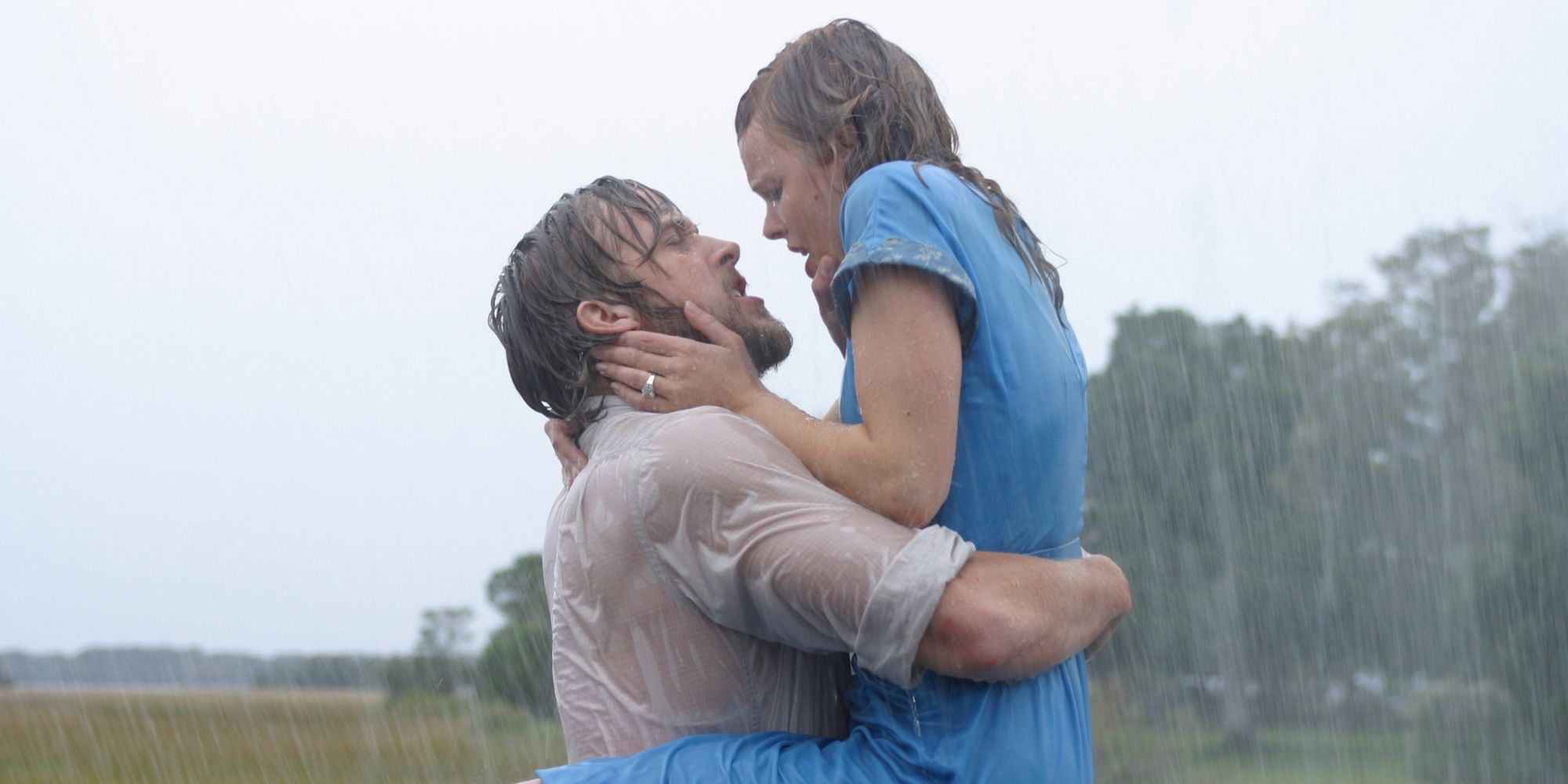 Noah (Ryan Gosling) holding Allie (Rachel McAdams) in his arms as they embrace in the rain in The Notebook.