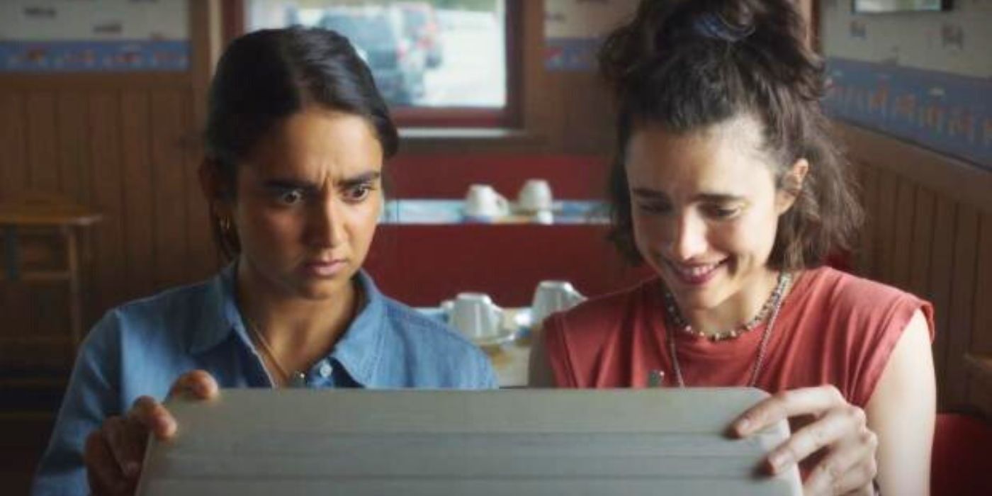 Jamie and Marian looking at the contents of a briefcase in Drive-Away Dolls