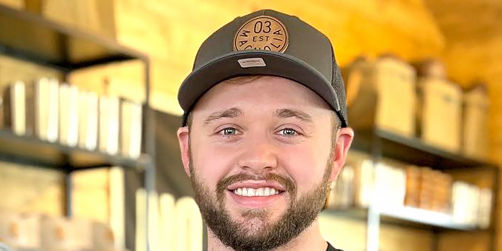 Jason Duggar smiling at the camera with a hat on