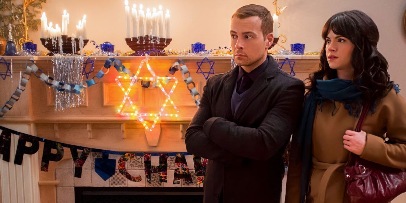 Joey Lawrence and Emily Hampshire standing in front of a Star of David in Hitched for the Holidays.