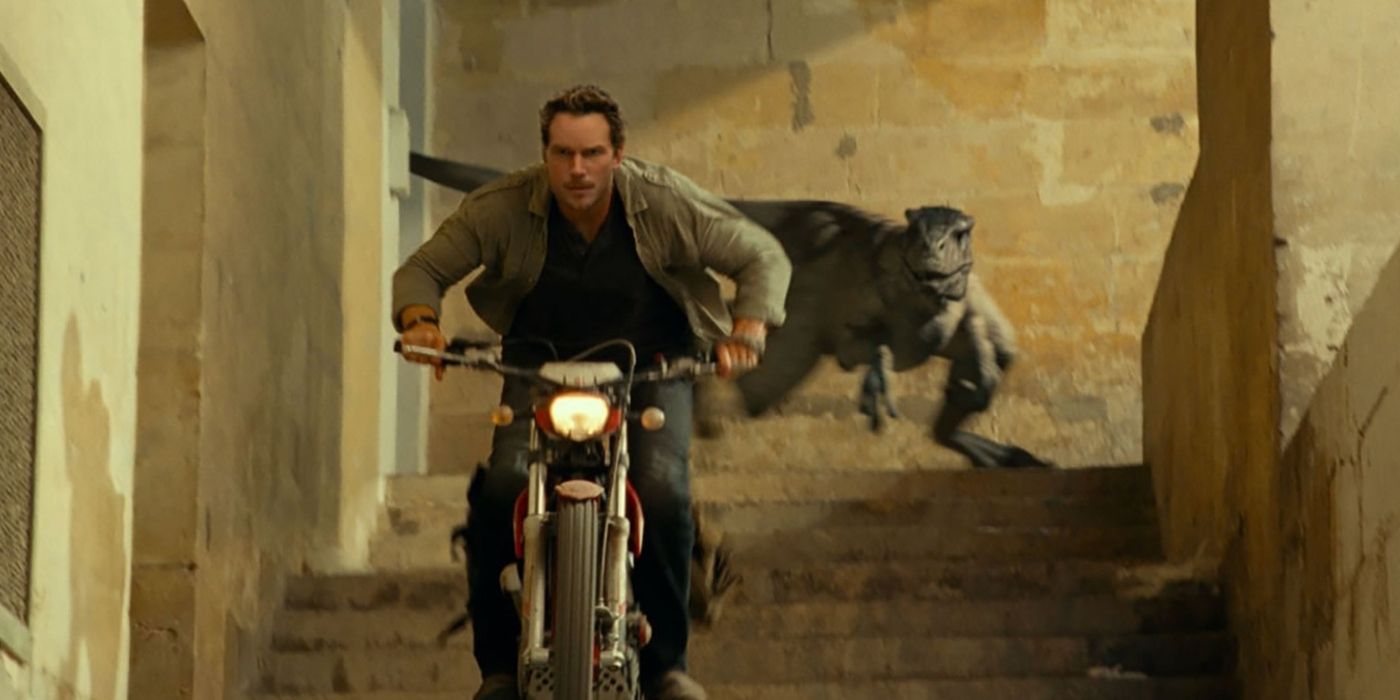 Chris Pratt as Owen Grady riding a motorcycle and being chased by a velociraptor in Jurassic World Dominion.