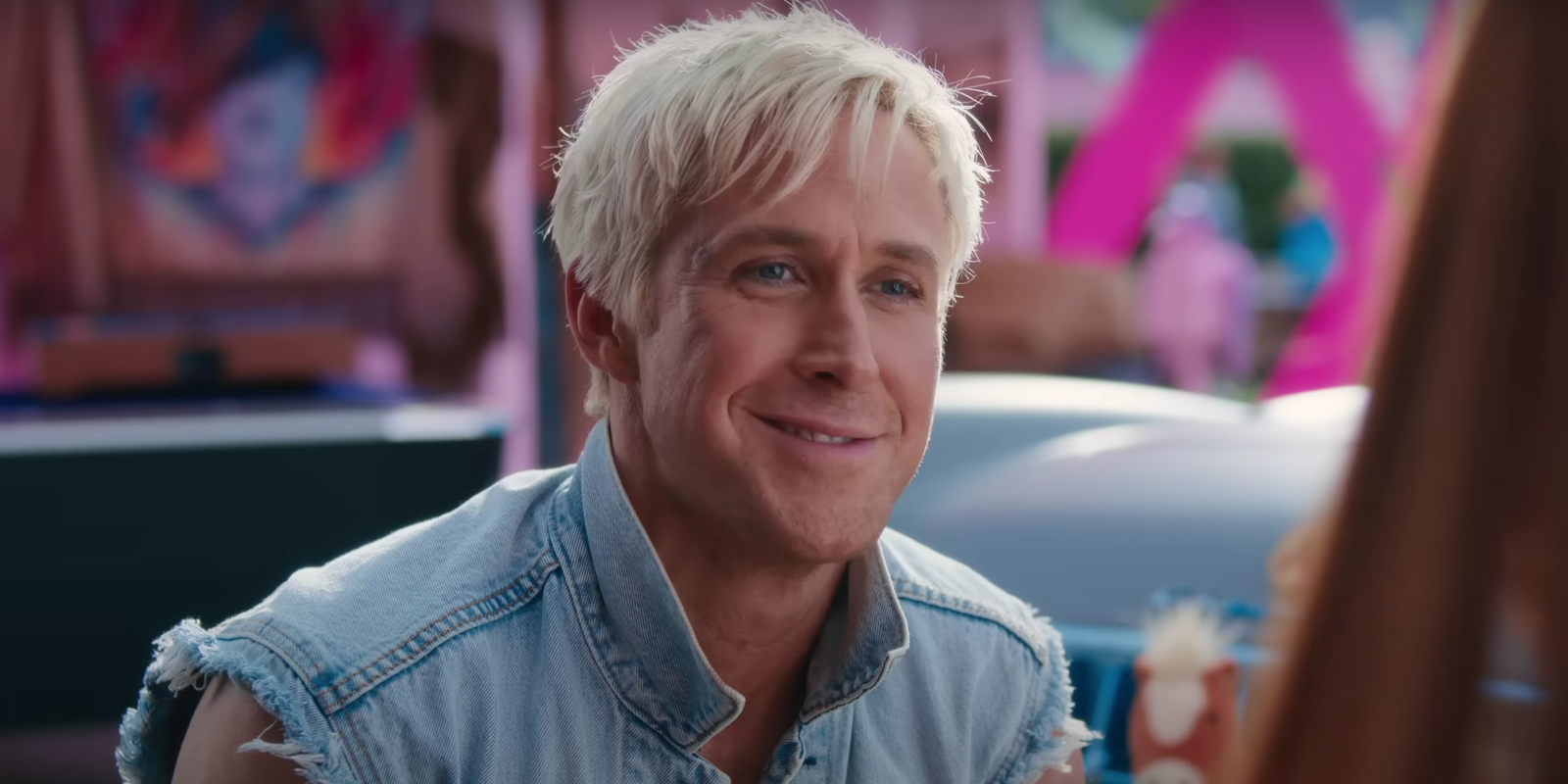 Ken wearing a denim vest while smiling in the Barbie movie