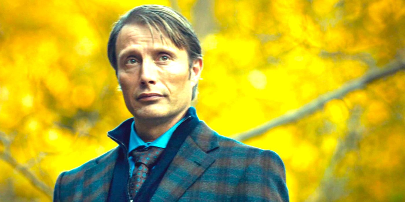 Mads Mikkelsen as Hannibal Lecter, wearing a sharp suit, standing in front of yellow autumn leaves