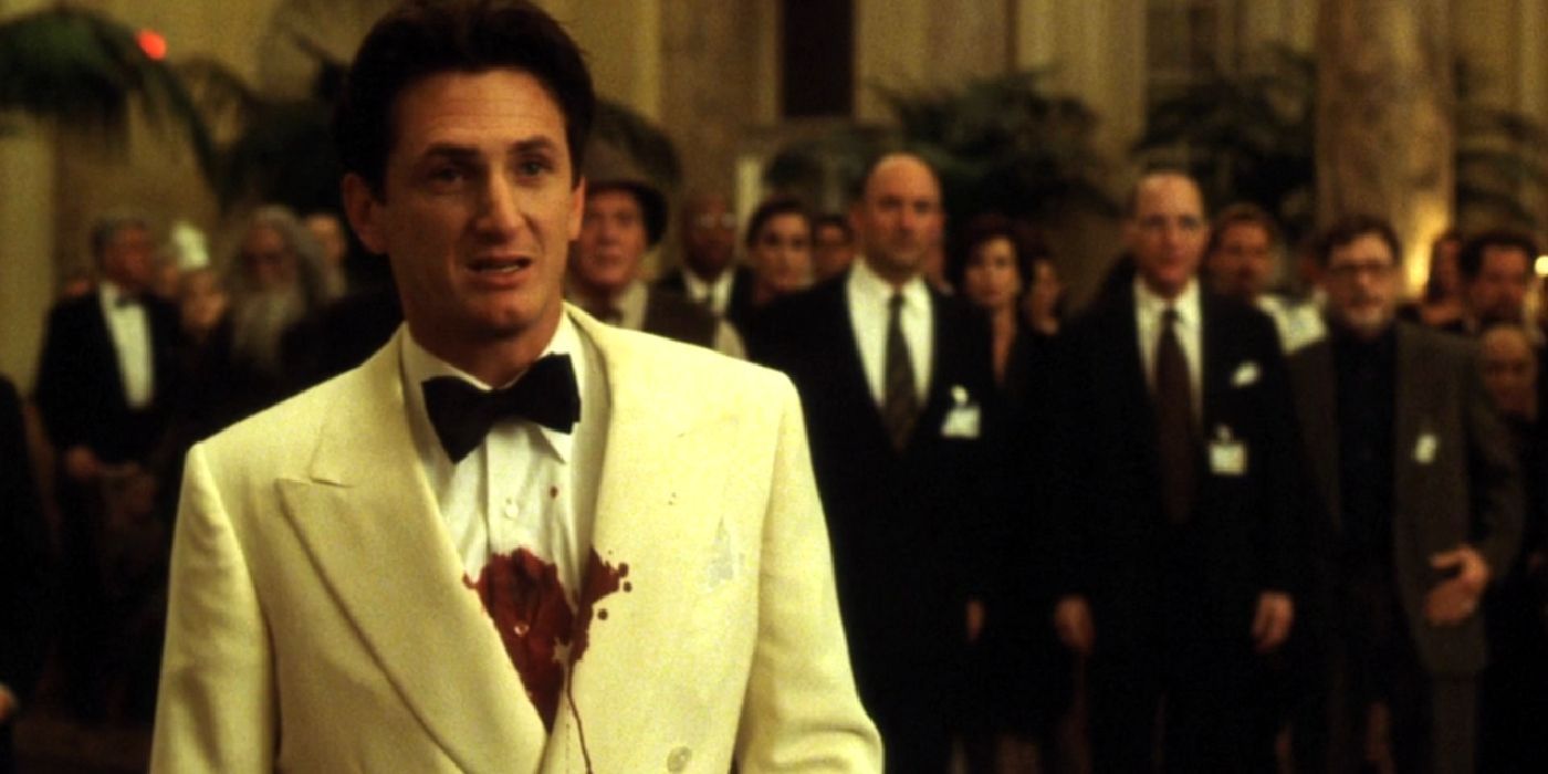 Sean Penn stands with a bloody chest while wearing a white tuxedo in The Game
