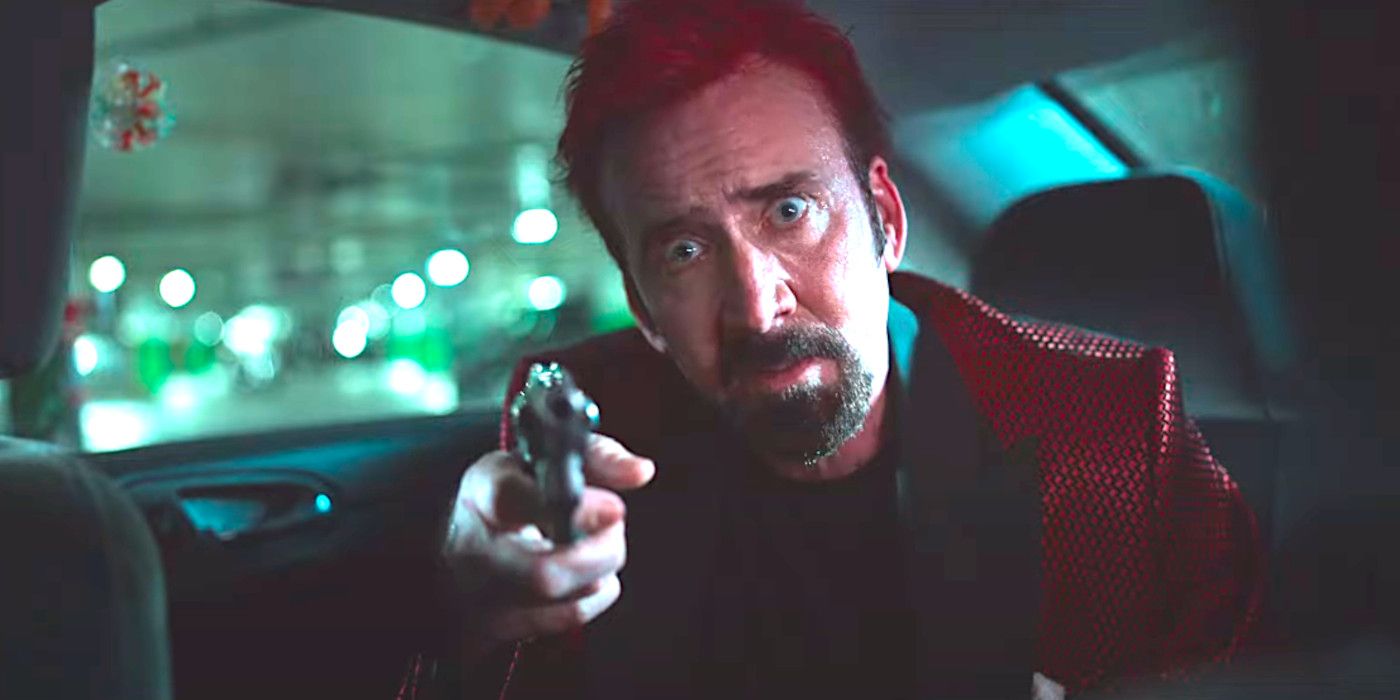 Nicolas Cage in Sympathy for the Devil sitting in the backseat of a car with big crazy eyes pointing a gun