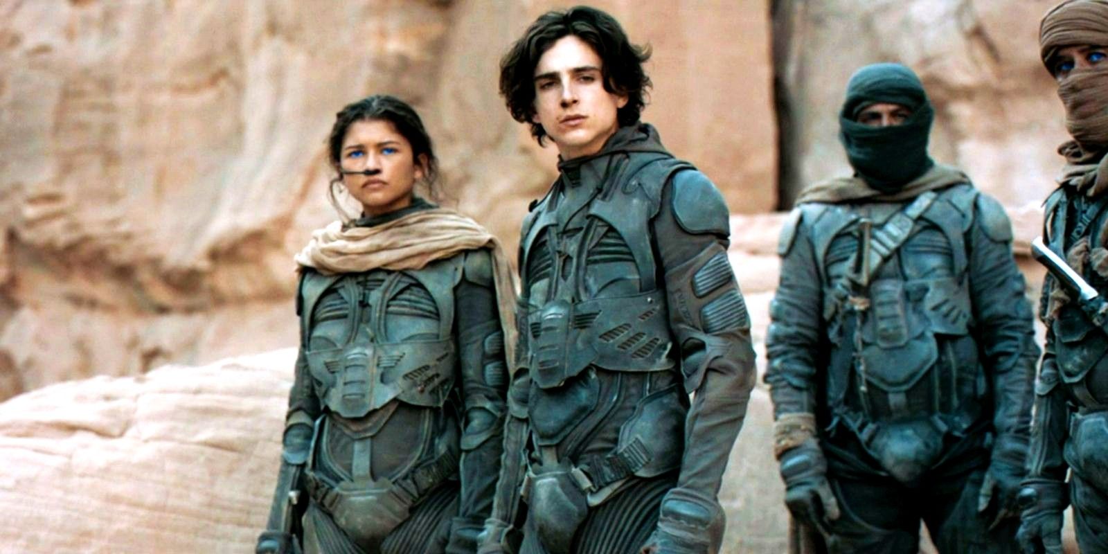 Paul e Chani estão com alguns Fremen em uma rocha em Dune