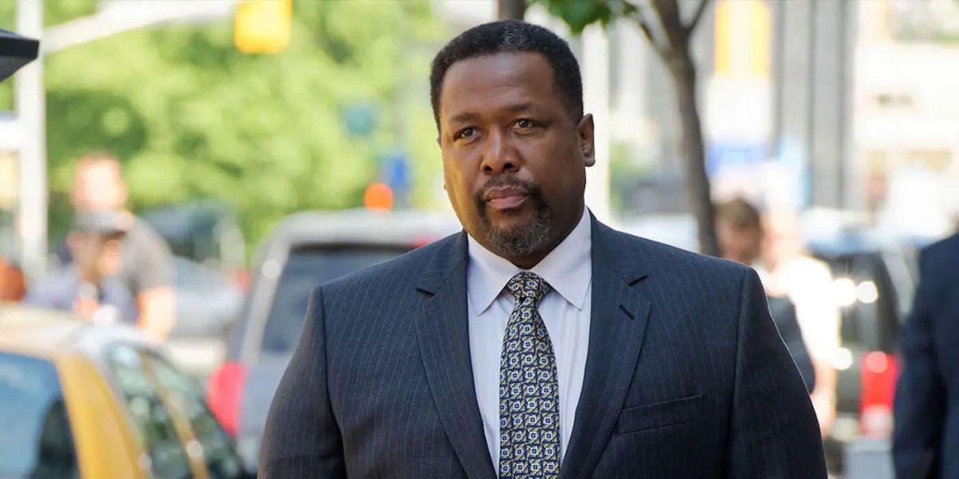 Robert Zane walks sternly on the street in Suits 