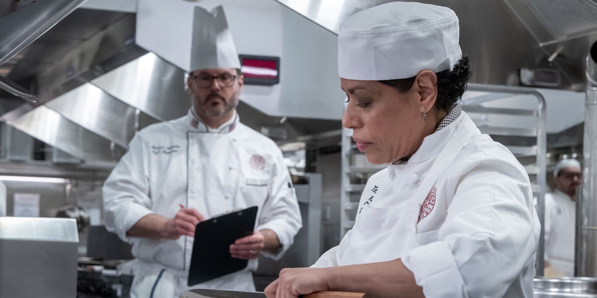 Liza Colon-Zayas enquanto Tina cozinha enquanto uma professora assiste no episódio 5 da 2ª temporada de The Bear