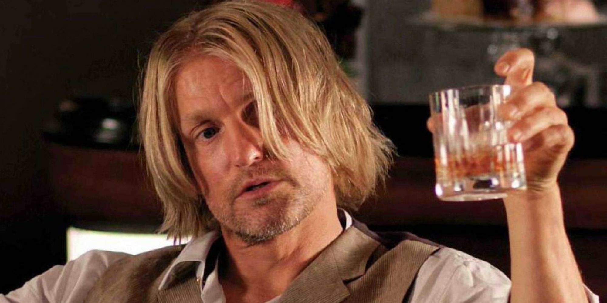 Haymitch holding a glass of alcohol in The Hunger Games