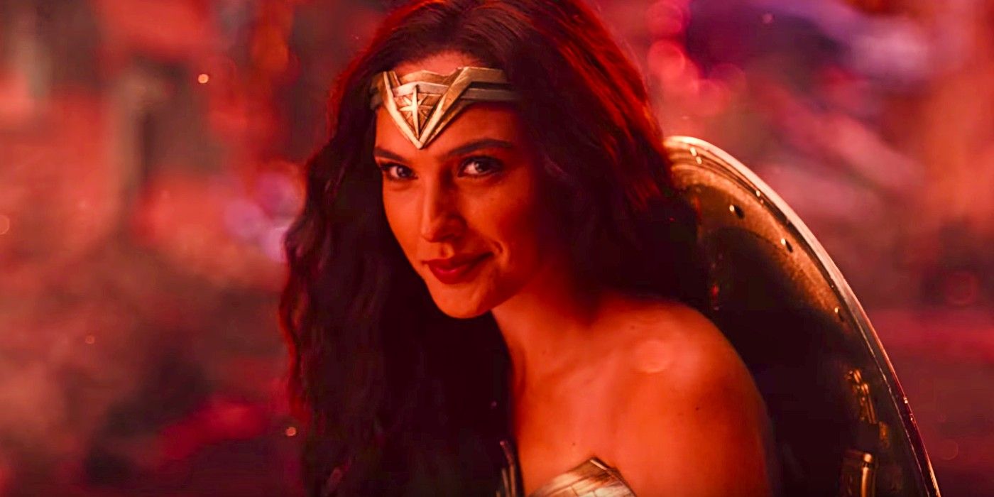 Gal Gadot's Wonder Woman smiling to the camera in front of a red background.