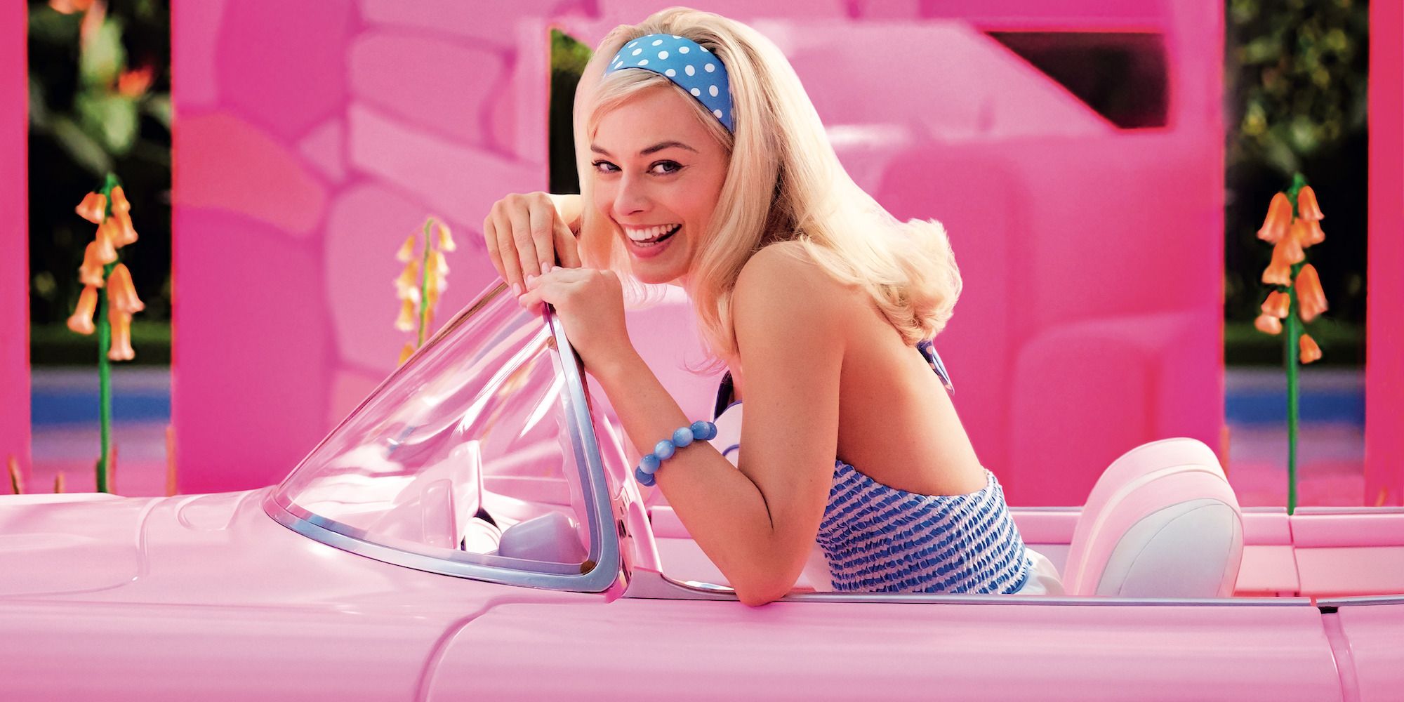 Margot Robbie as Barbie in her car in the movie Barbie.