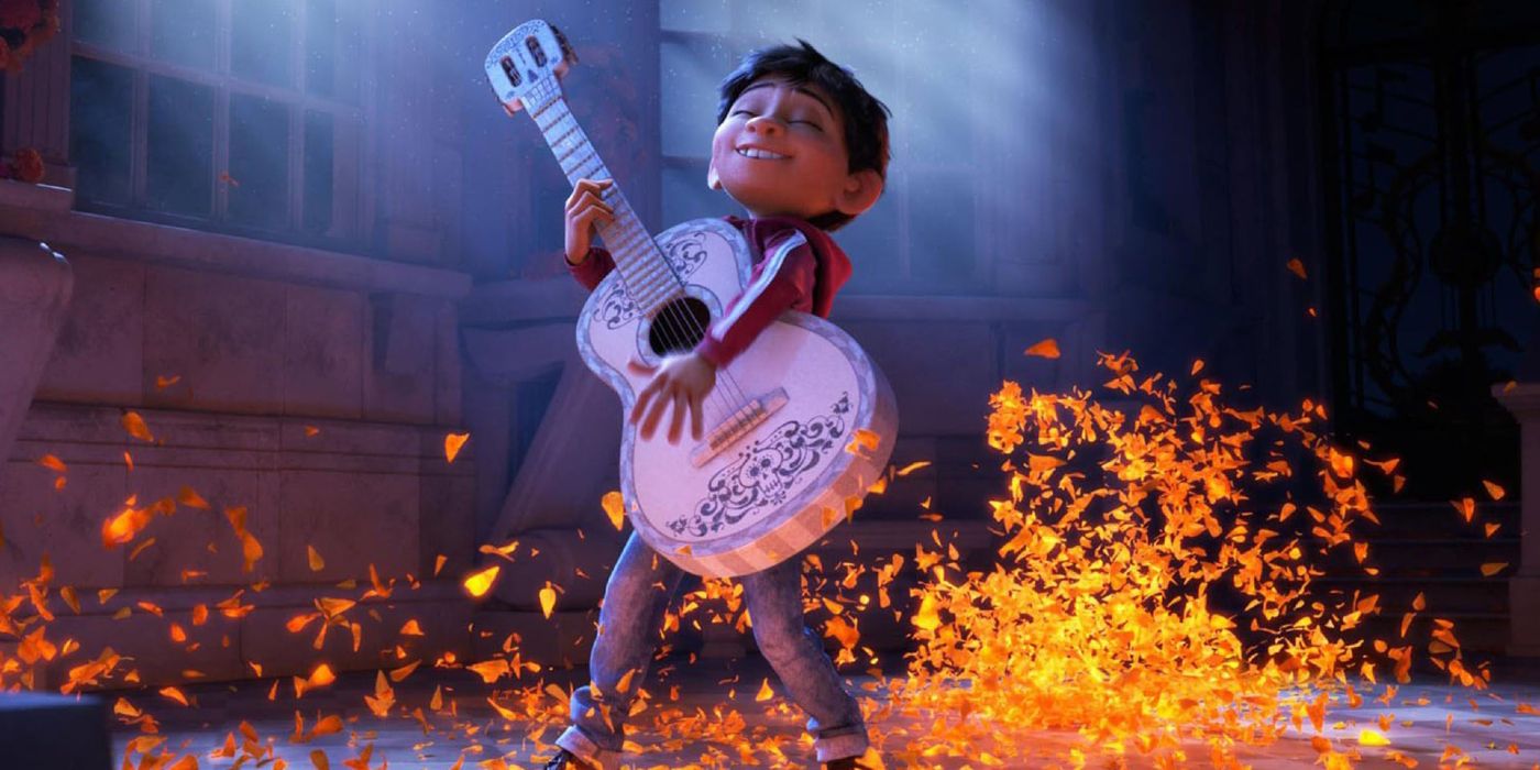 Miguel strums a guitar as marigold petals raise off the ground around him.