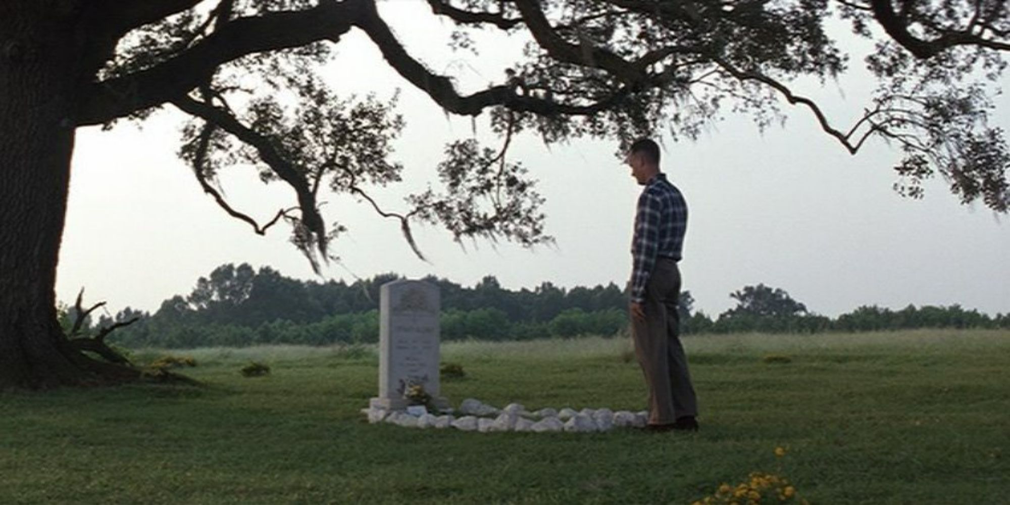Forrest (Tom Hanks) standing solemnly in front of a grave in Forrest Gump