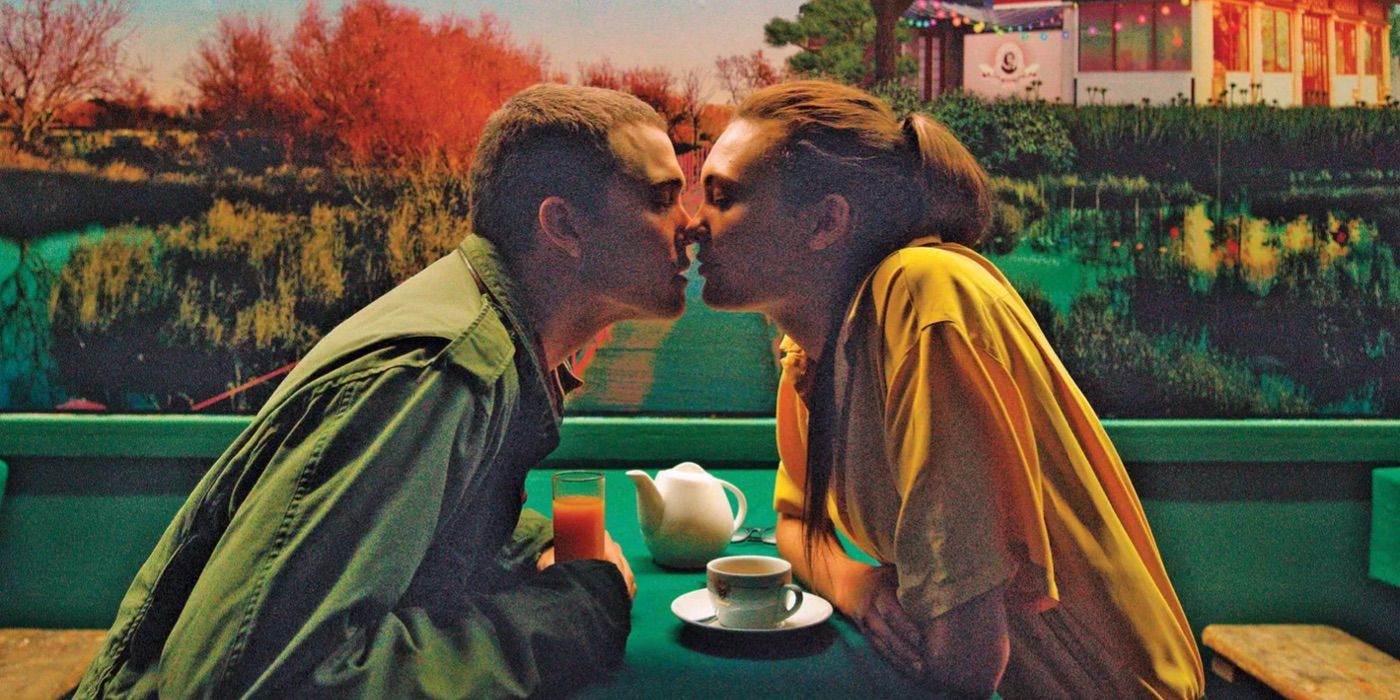 A couple kisses in front of a painted mural in Gaspar Noé's Love