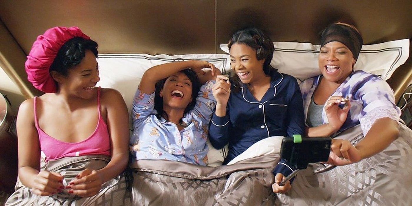 The cast of Girls Trip lying in bed.