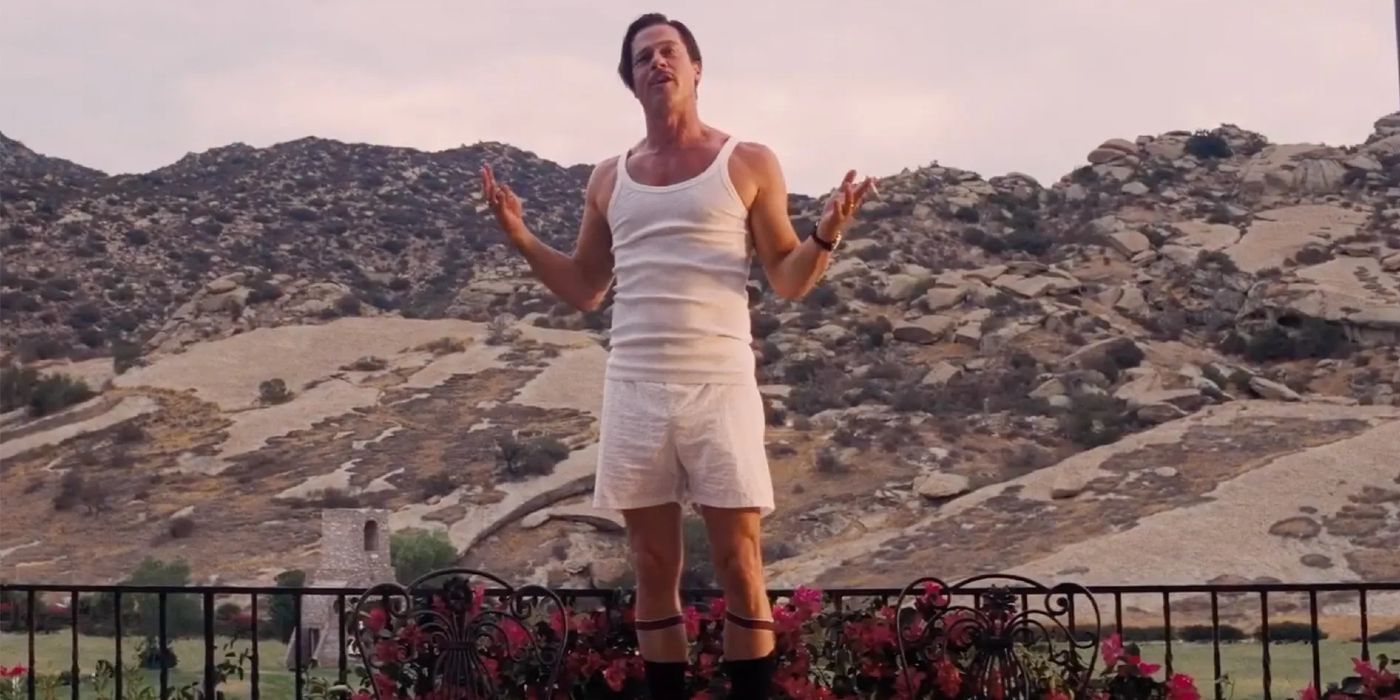 Brad Pitt stands on the balcony in front of a rocky landscape in Babylon