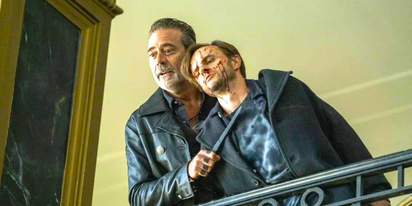 Jeffrey Dean Morgan as Negan in The Walking Dead: Dead City holding a knife to a man's neck on a balcony