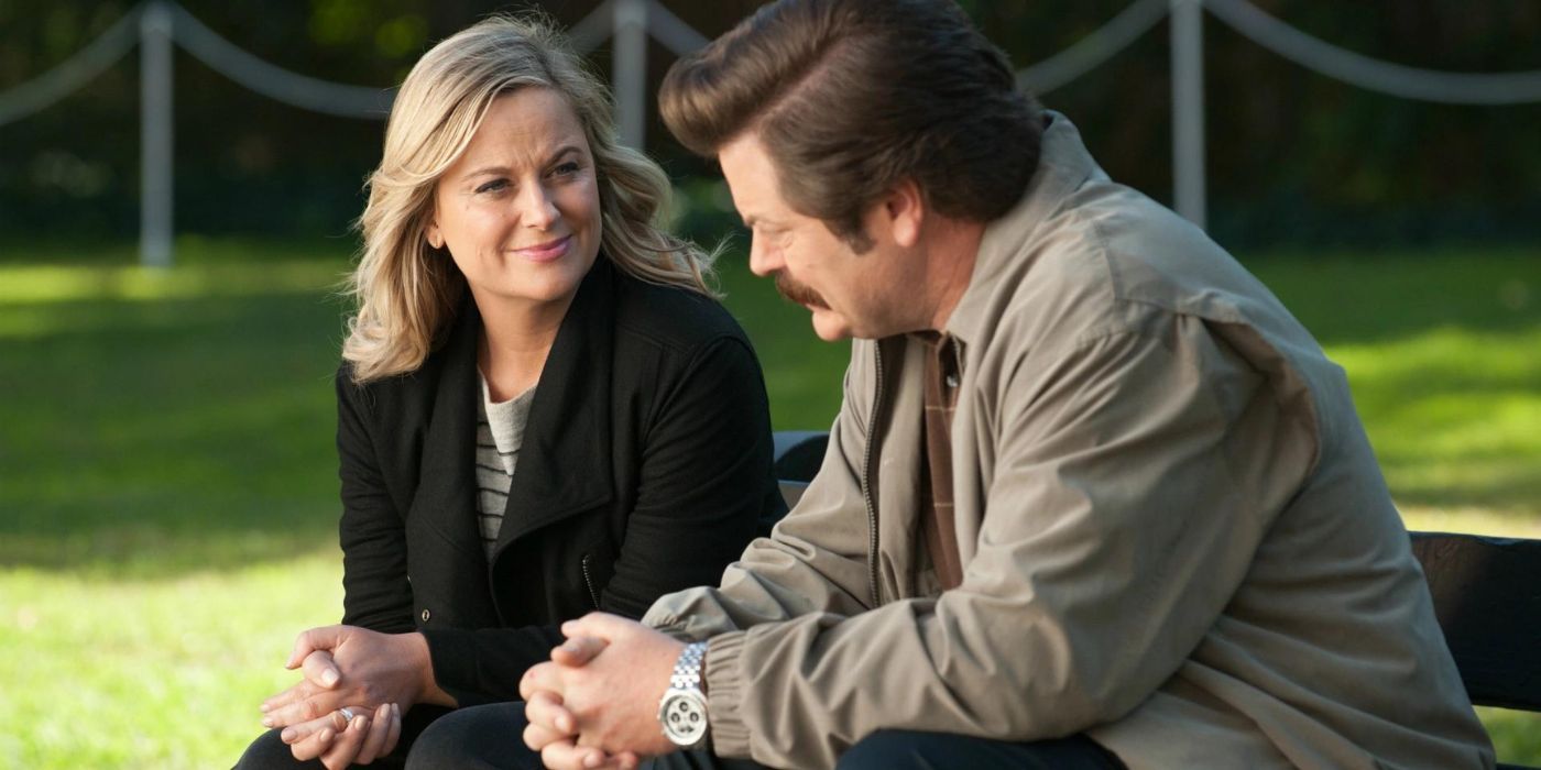 Leslie Knope and Ron Swanson chat on a bench in Parks and Recreation