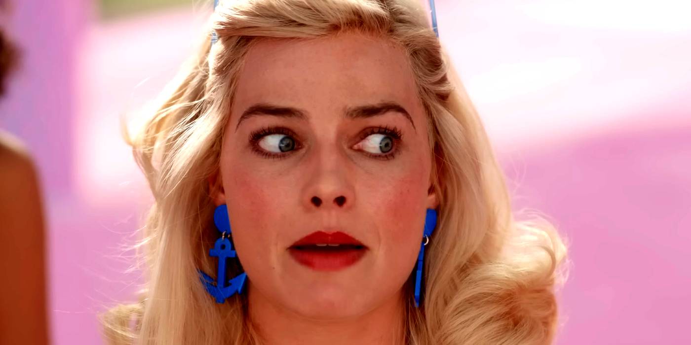 Margot Robbie looking perturbed as Barbie wearing blue anchor earrings