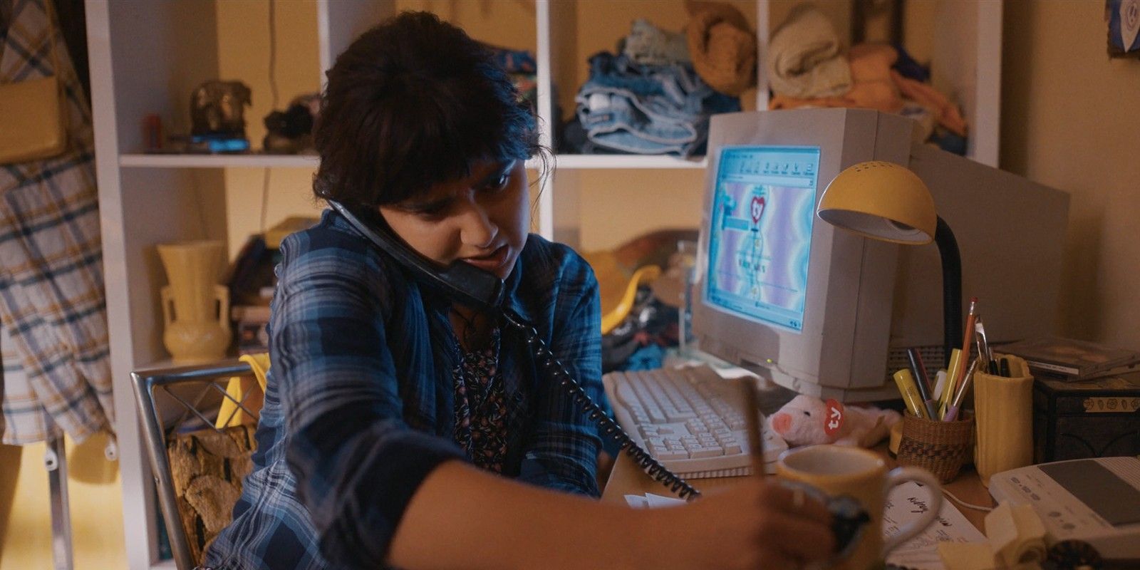 Maya writes something down while sitting in front of a computer showing the Beanie Babies website.