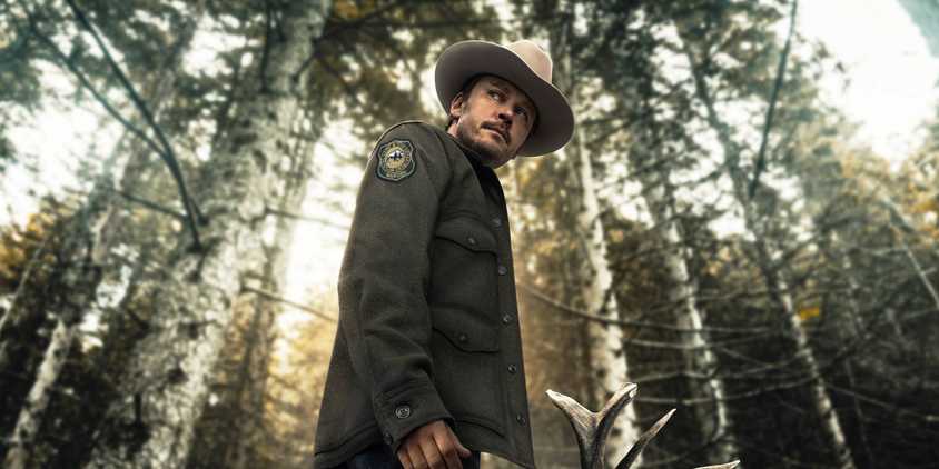 Michael Dornan in his game warden uniform among the trees in Joe Pickett