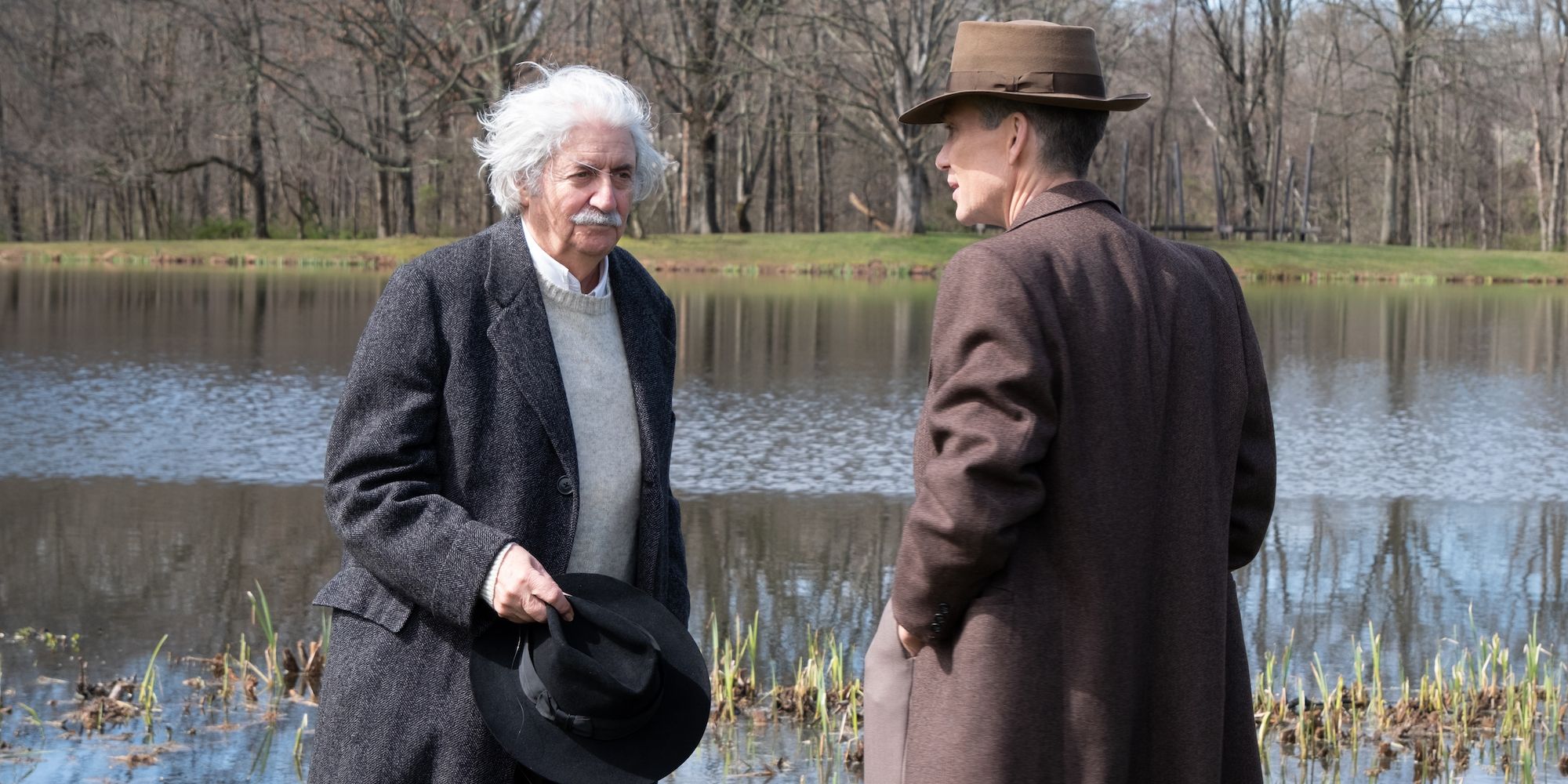 Einstein et Oppenheimer discutant au bord d'un lac à Oppenheimer