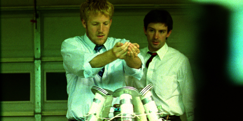 Primer 2004 character with cupped hands standing over a device