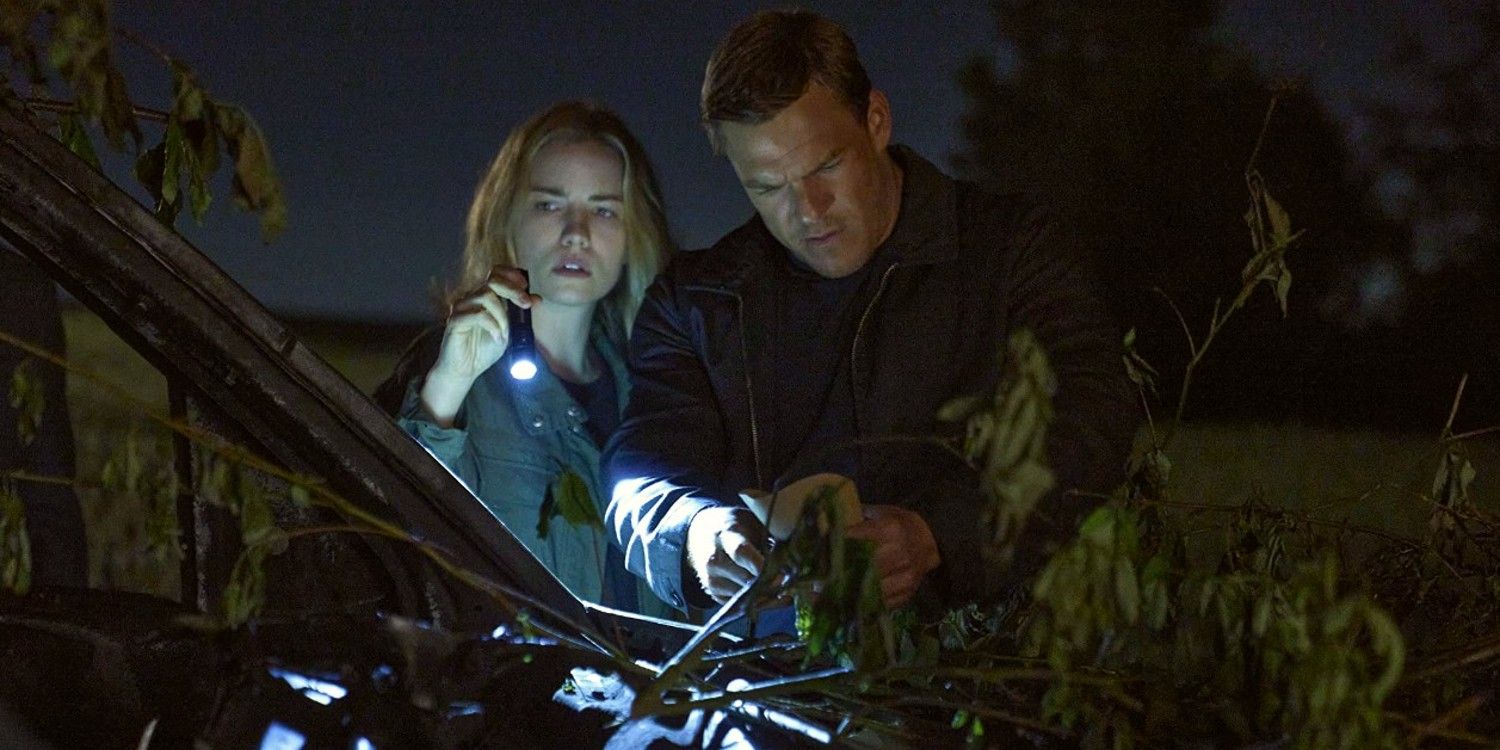 Jack Reacher and Roscoe looking at a branch with flashlights in Reacher season 1.