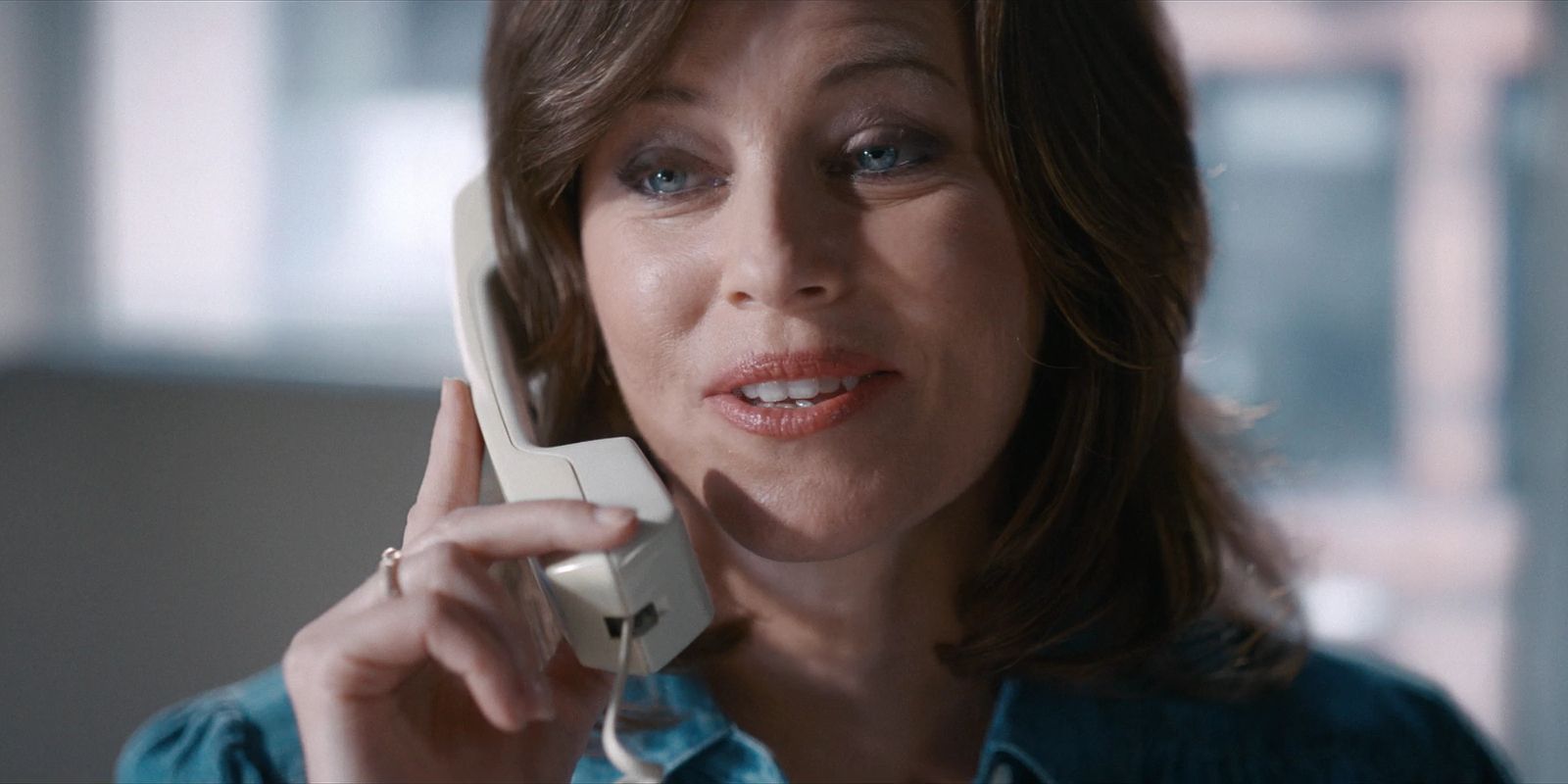 Robbie smiles while talking on the phone.