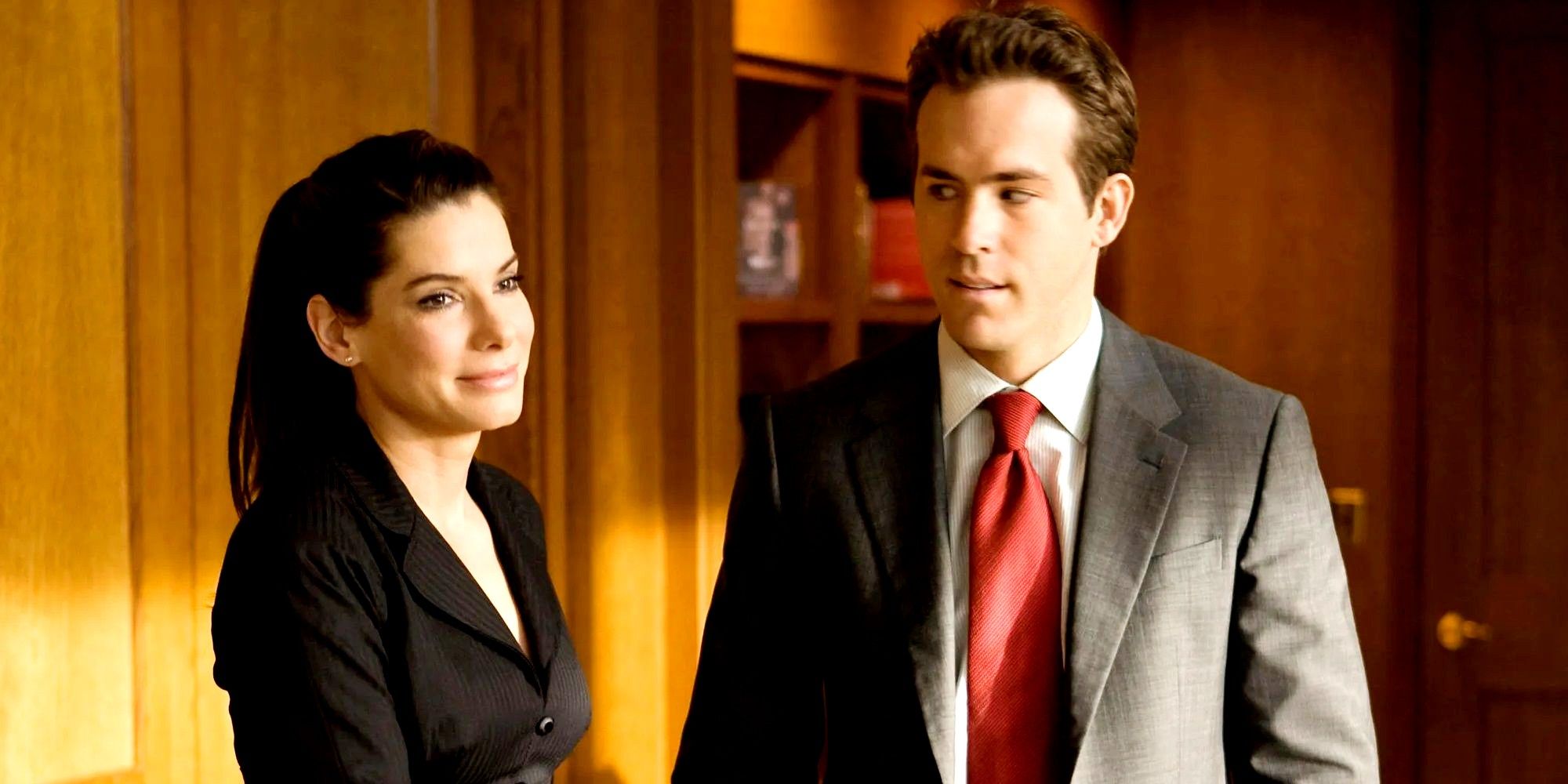Margaret (Sandra Bullock) and Andrew (Ryan Reynolds) stand together in her office in The Proposal.