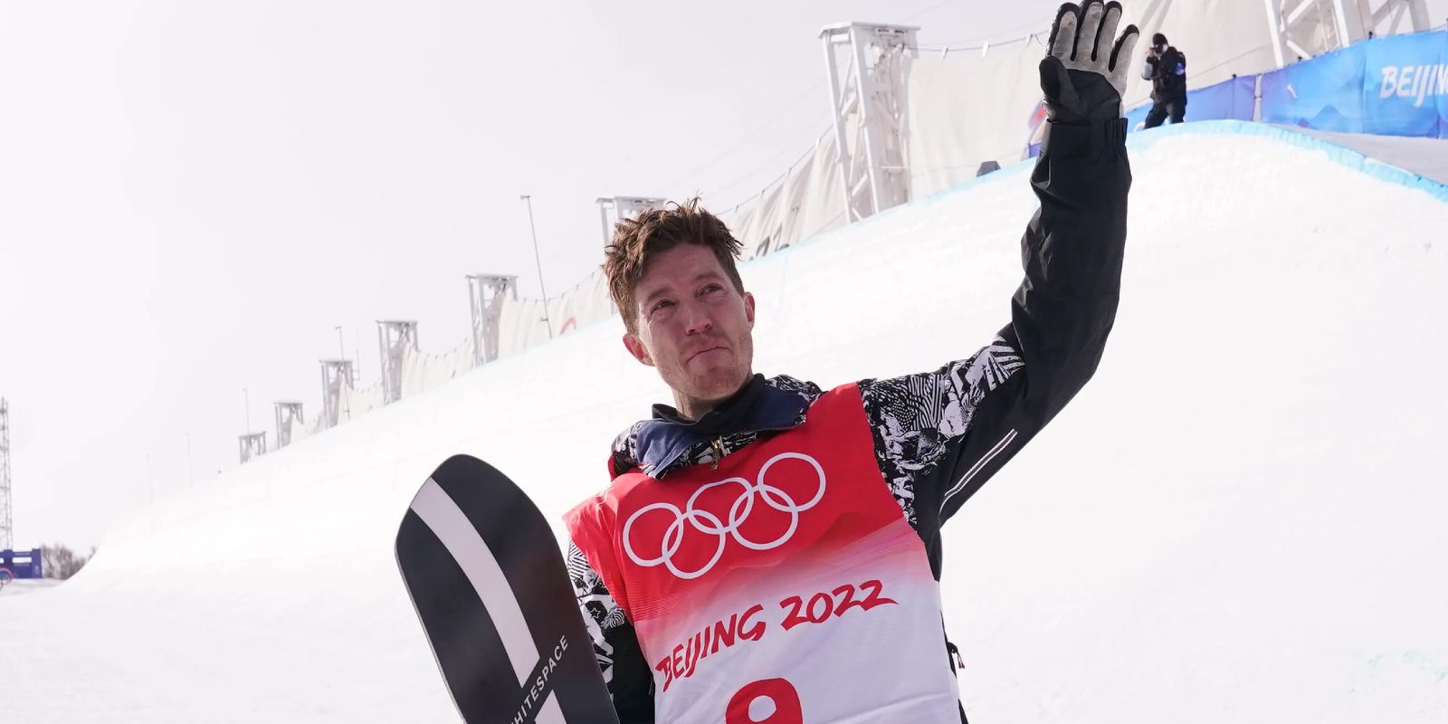 Shaun White raises his hand to the viewers after his last run at the Beijing 2022 Olympics.