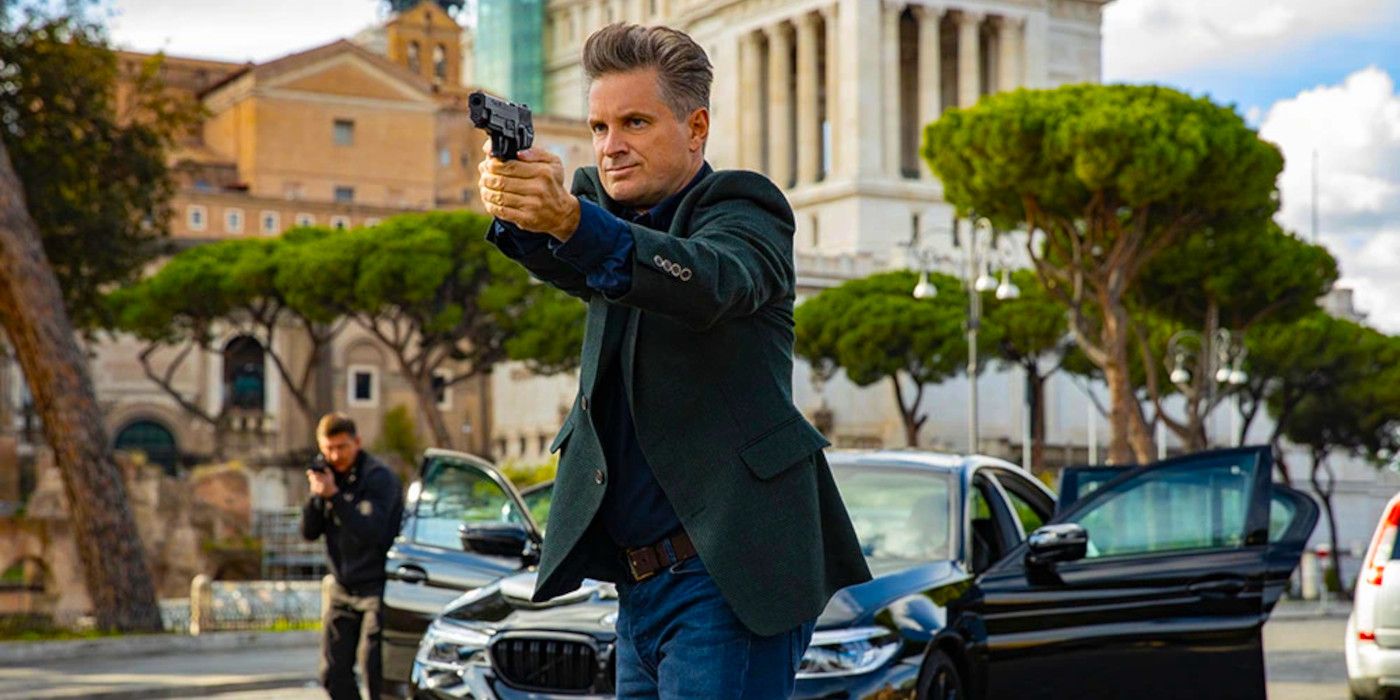 Shea Whigham in Mission Impossible 7 standing in the street aiming a gun