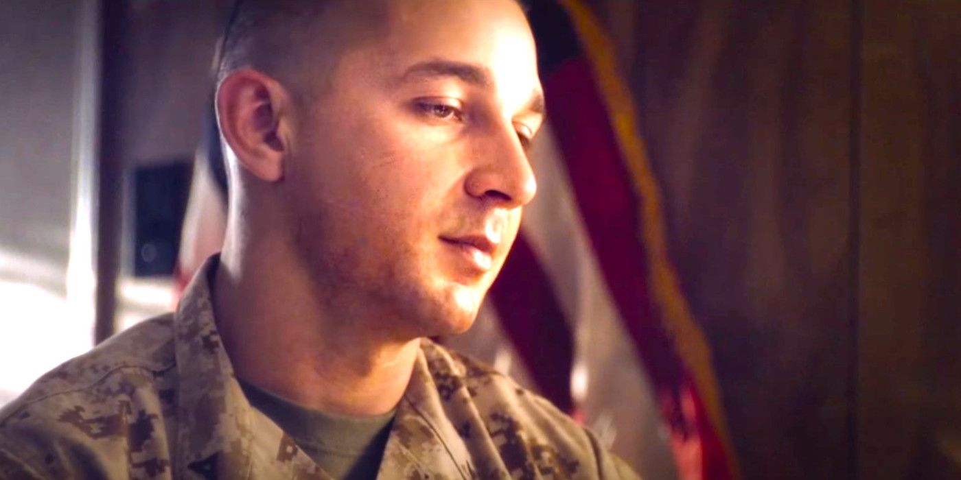 Shia LaBeouf in Man Down in military fatigues, sitting before a US flag, looking pensive