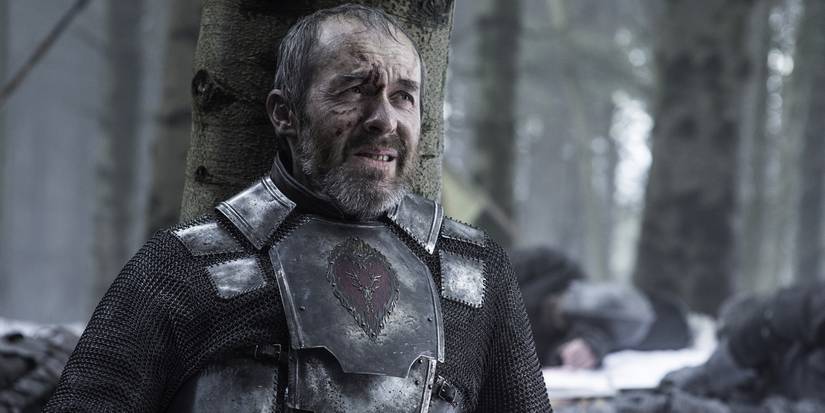 Stannis leans on a tree in Game of Thrones