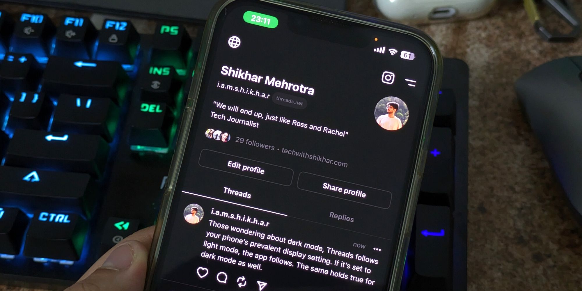 Image of an iPhone with the Threads app on the display in dark mode