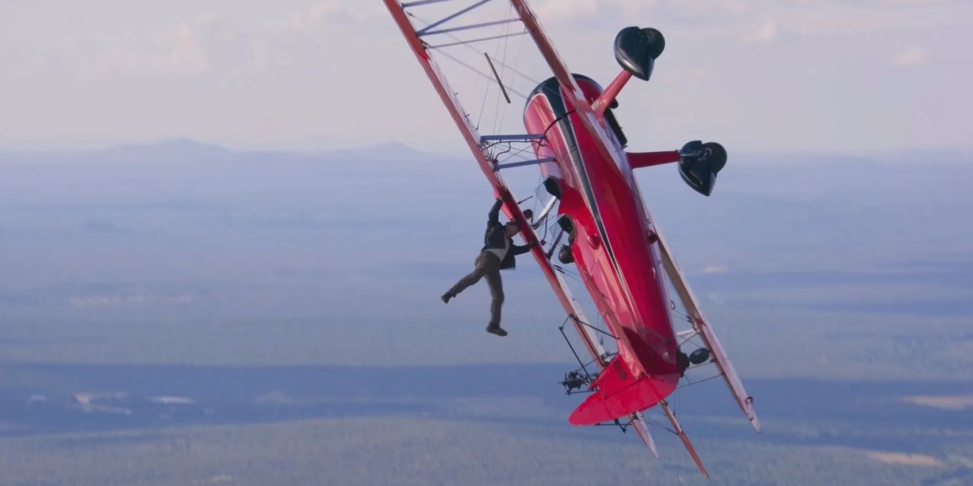 Tom Cruise hanging upside down from a biplane.