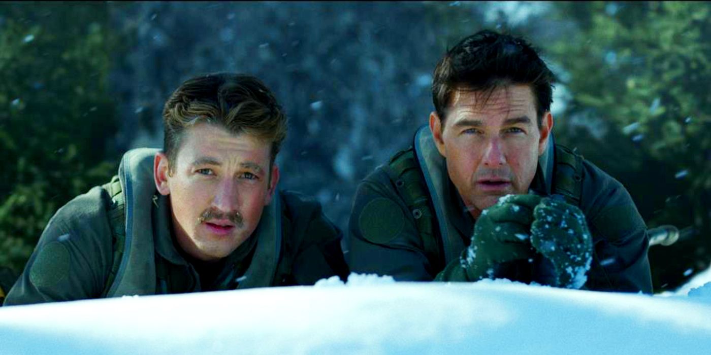 Miles Teller as Rooster and Tom Cruise as Maverick hiding behind a snowbank in Top Gun 2