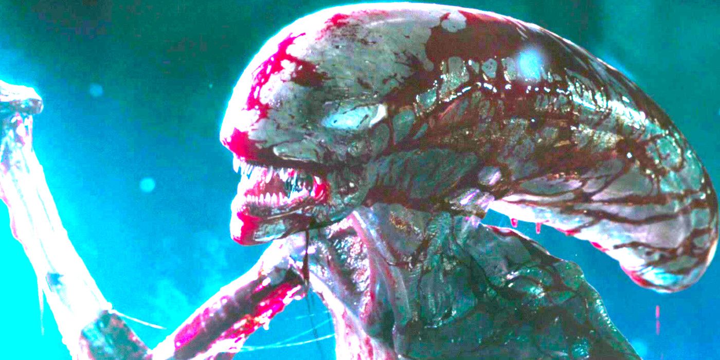 Xenomorph from alien covenant baring its sharp white teeth while spattered with blood