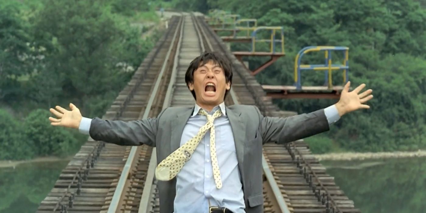 A man looking angrily upwards while standing on a train track in Peppermint Candy