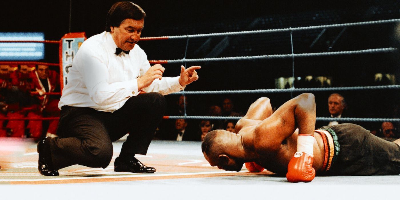 A referee counting down while a boxer lays down in the ring  in Losers