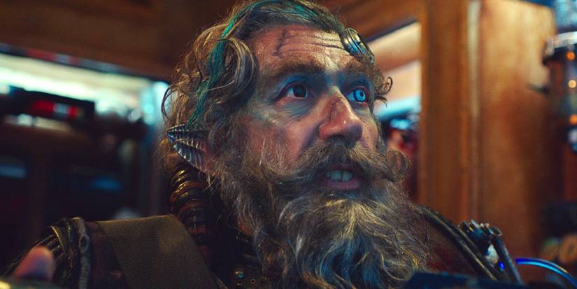 Alain Chabat as Bob the Piratye sitting down in Valerian