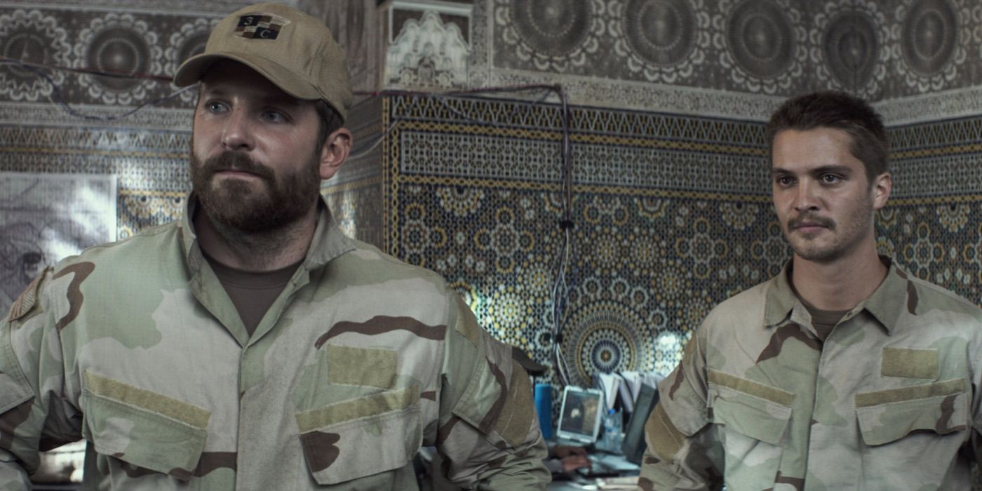 Bradley Cooper and Luke Grimes as Chris Kyle and Marc Lee look on in American Sniper.