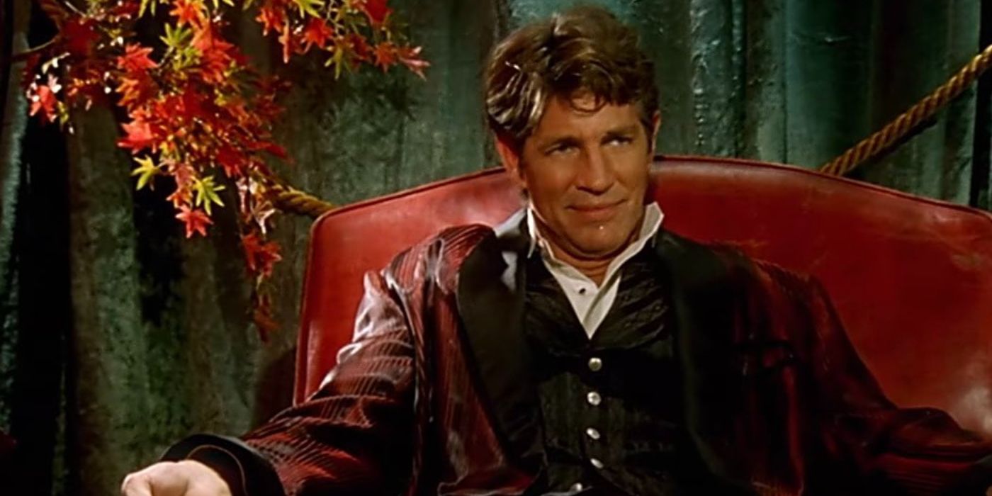 An image of Eric Roberts smiling smugly in a chair in the Mr. Brightside video