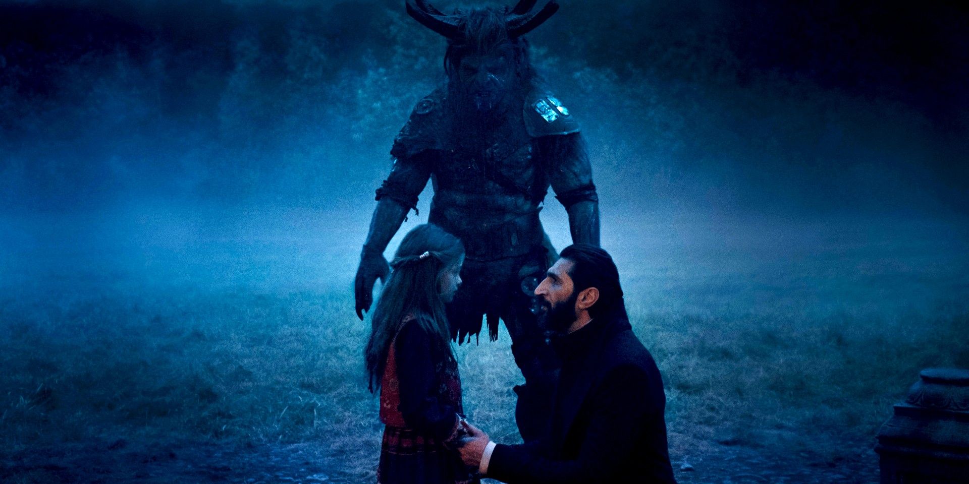 An older man talks to a young girl as they see a creature in Wheel of Time season 2