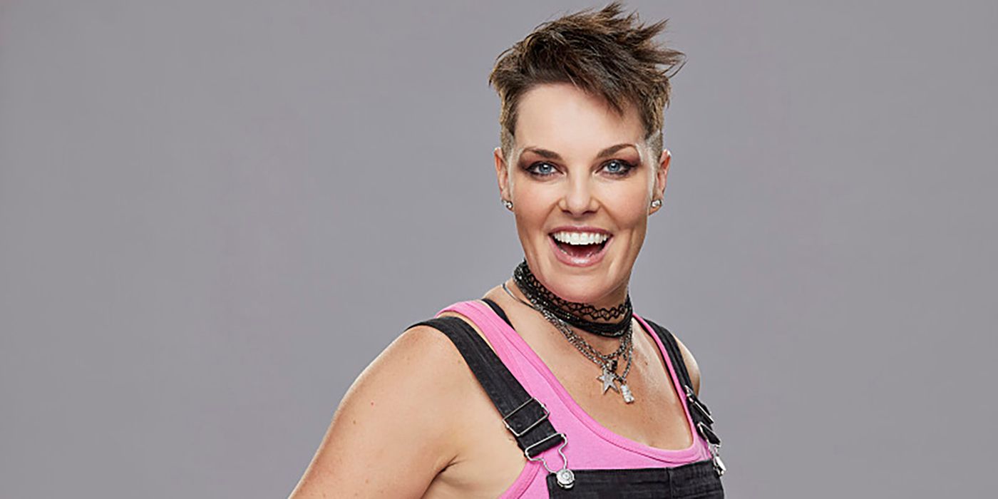 Big Brother 25's Bowie Jane wearing pink and black, smiling, against a gray background