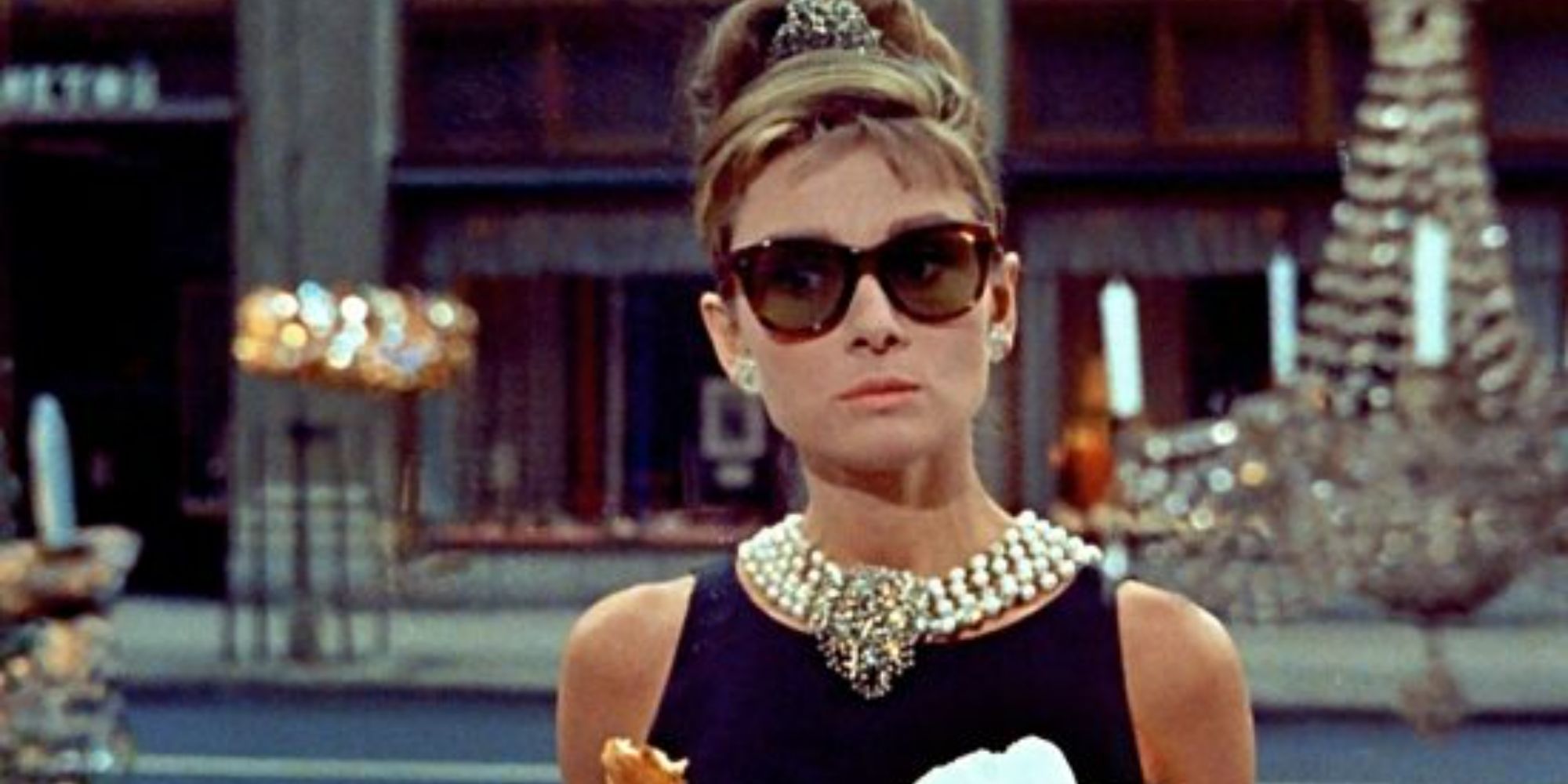 Holly Golightly eating a pastry and standing outside Tiffany's in Breakfast at Tiffany's